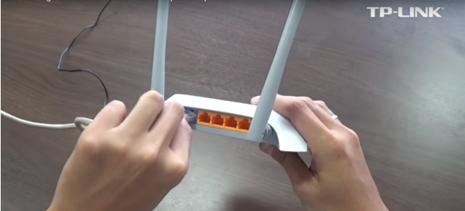 192.168.1.1 - Login e Configuração do Roteador Wi-Fi Mãos de uma pessoa instalando os cabos do roteador tp-link